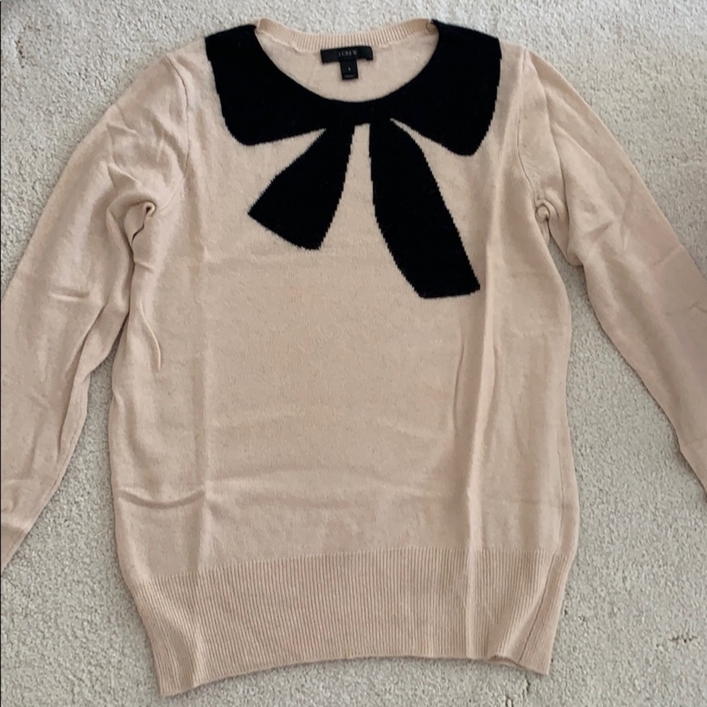 cream colored sweater with black bow design